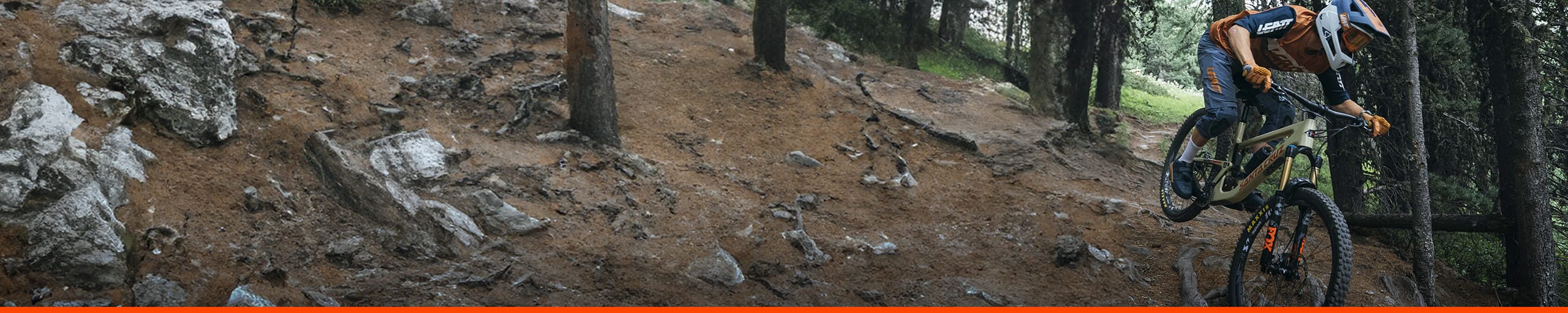 VTTiste en sous bois roulant sur un VTT équipé de pneus MAXXIS