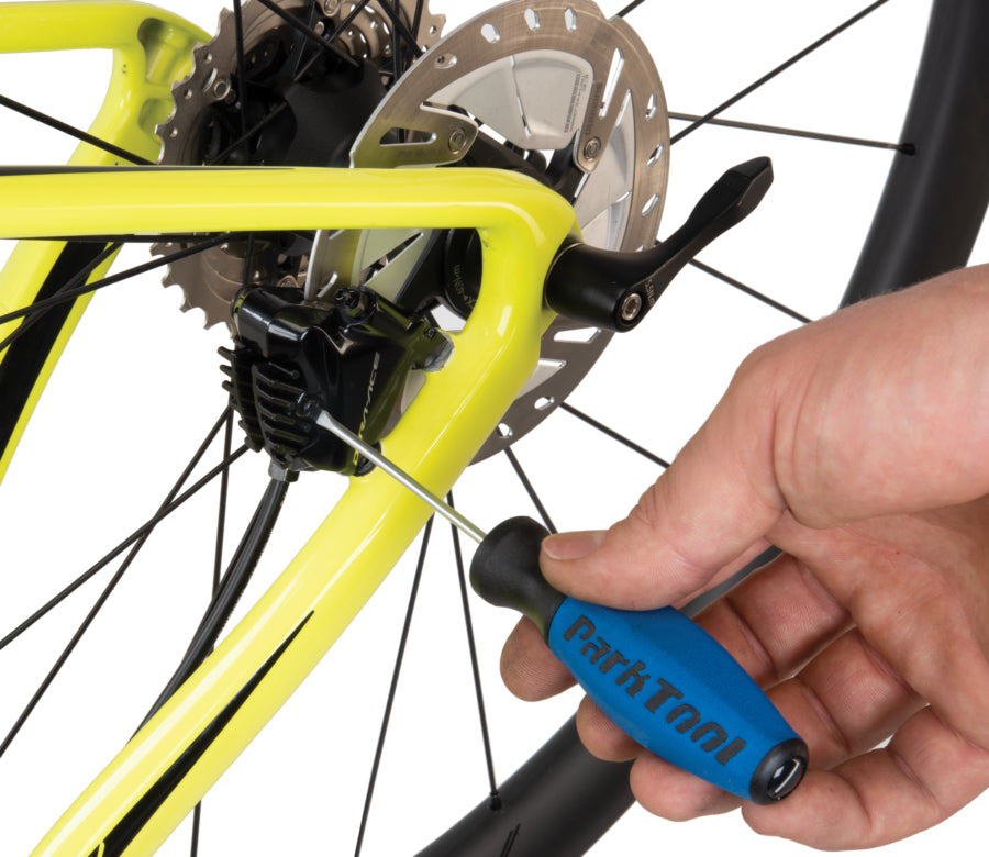 Park Tool SD-3 destornillador plano sobre una pinza de freno hidráulico