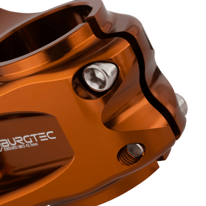 Potencia BURGTEC ENDURO MK3 bronce — detalle de la sujeción del tubo de dirección