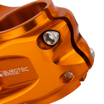 Potencia BURGTEC ENDURO MK3 naranja — detalle de la sujeción del tubo de dirección