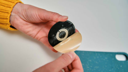 Parche FIDLOCK VACUUM para smartphone universal negro — retirada de la película adhesiva antes de colocar el parche negro
